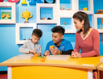 Kids and parents are playing with LEGO® bricks and learning tips and tricks. A fun family activity!
