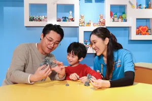 At LEGO® Creative Workshop, a kid is building LEGO® models, guided by a Master Model Builder.