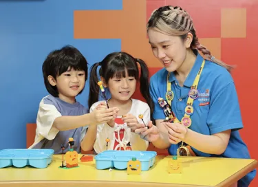 Master model building interacting with kids at Creative workshop.