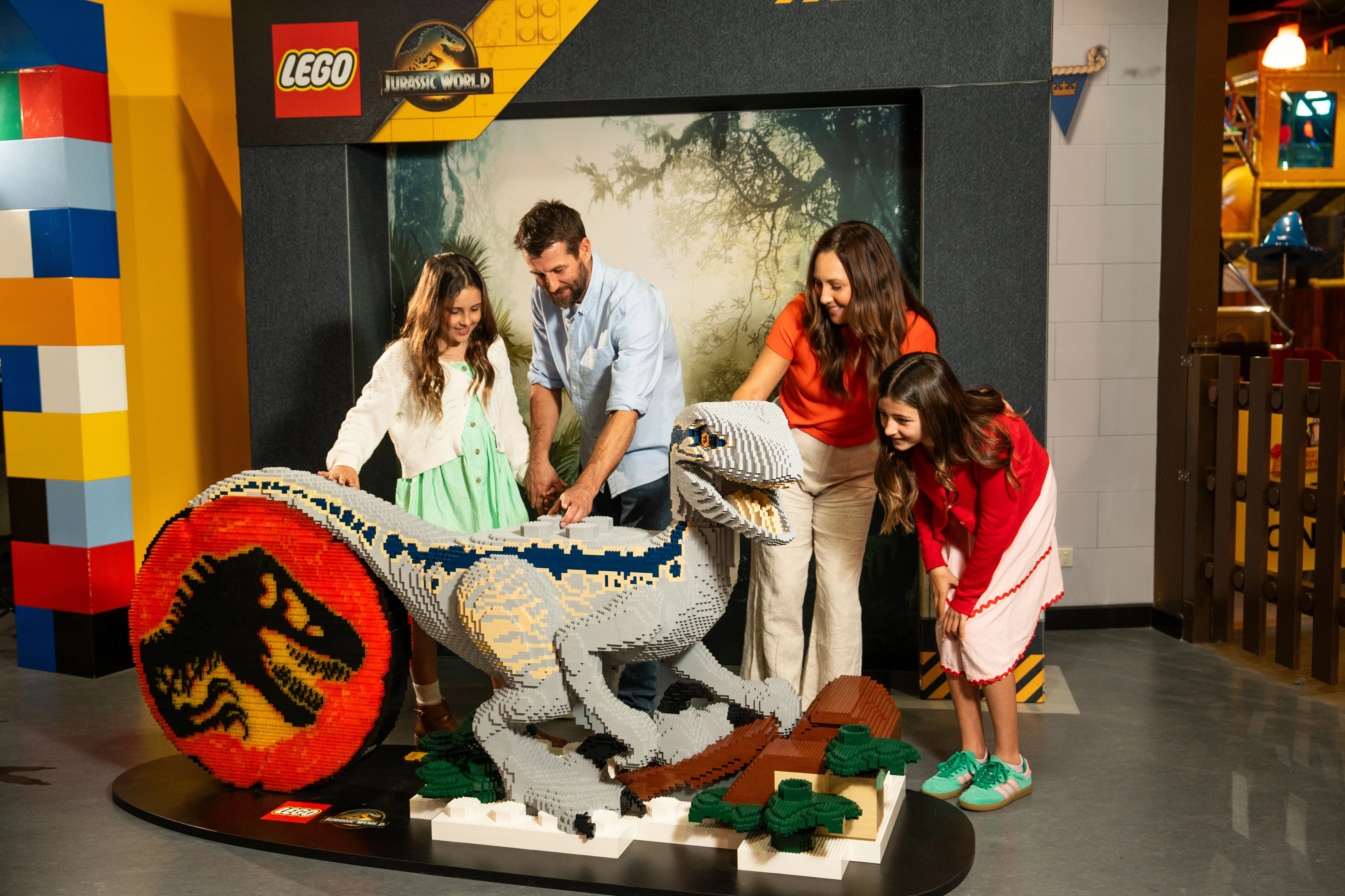 Family interacting with Blue the LEGO brick-built raptor